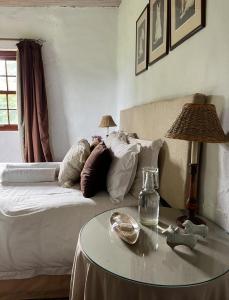 Habitación con cama con almohadas y mesa. en Pear Tree Cottage-Underberg, en Underberg 16 fotos más