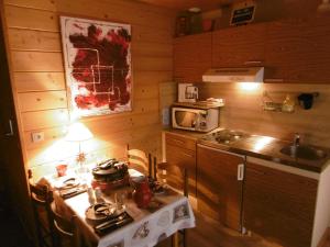 une petite cuisine avec une table et un four micro-ondes dans l'établissement Gite Au Coeur Du Chalet en Belledonne vers Prapoutel Les 7 Laux, à Sainte-Agnès