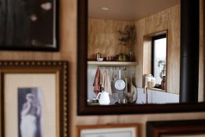 a mirror in a room with pictures on the wall at Just Down the Road in Branxholm +31 photos