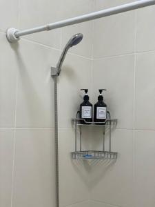 a shower with two bottles on a shelf in a bathroom at Красивые апартаменты на Экспо in Taldykolʼ +24 photos
