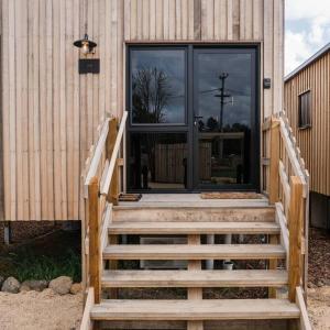 a wooden staircase leading to a door of a building at Just Down the Road in Branxholm