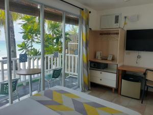 a room with a bed and a kitchen with a balcony at Bluewaves Beach House in Boracay