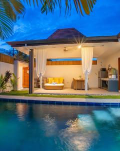 a villa with a swimming pool at night at Bali Villas Panglao Bohol in Panglao