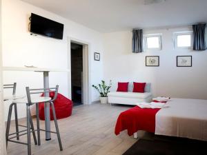 Apartment Onyx في سبليت: غرفة بيضاء مع سرير وبطانية حمراء
