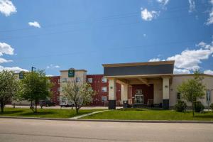 a large red brick building with a clock on it at Quality Inn & Suites in Whitecourt