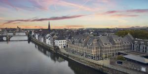Una vista de una ciudad con un río y edificios. en Crowne Plaza Maastricht by IHG, en Maastricht