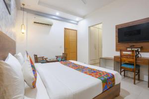 Кровать или кровати в номере FabHotel New Journey Hospitality Near MG Road & Sikanderpur Metro