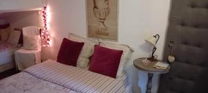 una camera da letto con un letto con cuscini rossi e un tavolo di Le Chai de Serres a Artassenx Altre 11 foto