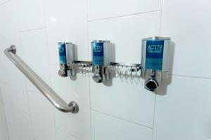 box doccia con una bottiglia di sapone blu sul muro di Four Points by Sheraton Queretaro Norte a Querétaro