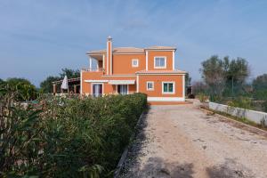 a large orange house on top of a dirt road at Moradia Malhao in Malhão