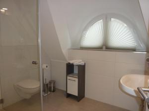 a white bathroom with a toilet and a sink at Ferienhaus TraumZeit in Pepelow