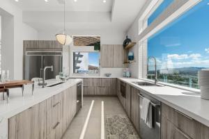 丝兰谷The Overlook by Fieldtrip 5 Bd Modern Luxury with Infinity Pool Views的一个带木制橱柜和大窗户的厨房