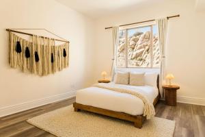 a bedroom with a bed and a window at Casa Blanca by Fieldtrip Boulder Estate with Hot Tub Soaking Pool Outdoor Shower in Yucca Valley