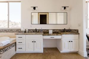a white bathroom with a sink and a mirror at Casa Blanca by Fieldtrip Boulder Estate with Hot Tub Soaking Pool Outdoor Shower in Yucca Valley +35 photos