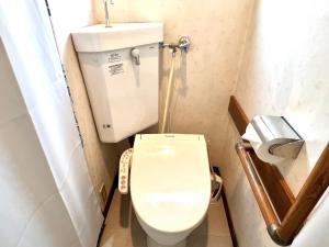 a small bathroom with a toilet and a toilet paper dispenser at 大久保4分新大久保8分テラス付き in Tokyo +27 photos
