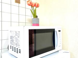a white microwave with a vase on top of it at 大久保4分新大久保8分テラス付き in Tokyo