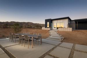 a dining table and chairs on the patio of a house at Alta House by Fieldtrip Near Park Entrance with Pool Spa Casita in Joshua Tree