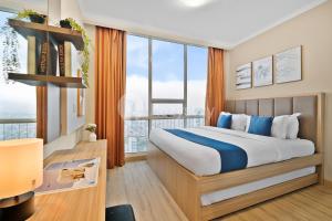 a bedroom with a large bed and large windows at Arcus by Kozystay - Ancol in Jakarta +18 photos