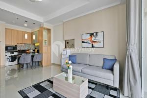 a living room with a couch and a kitchen at Arcus by Kozystay - Ancol in Jakarta