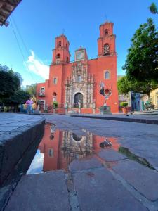a building with a reflection in a puddle in front of it at Casa Antares24, Departamento de confort y descanso in Guanajuato