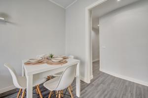 Un comedor blanco con una mesa y sillas blancas. en Múgica - Gran Vía, en Logroño
