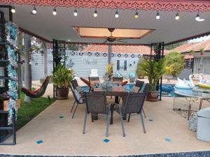 a patio with a table and chairs under a pergola at Phala Sunshine Villa in Ban Phala