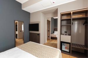a bedroom with a bed and a flat screen tv at Hotel San Remo in Rome