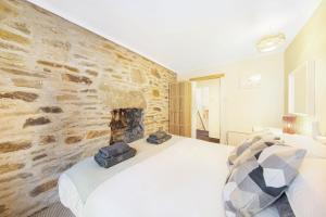 a bedroom with a stone wall and a bed at Host & Stay - Batemill Cottage in Birch Vale +6 photos