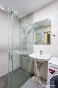 a bathroom with a glass shower and a sink at Bangų g. Apartamentai in Klaipėda