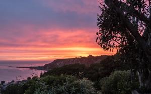 a sunset over the ocean with a mountain at Spectacular Views, Convenient, Affordable - KK17129 in Kaikoura
