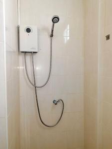 a shower with a shower head in a bathroom at Baan Thawin in Patong Beach +26 photos