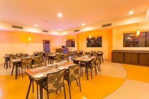 restauracja ze stołami i krzesłami w pokoju w obiekcie Ginger Pondicherry w mieście Puducherry