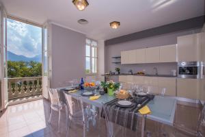 a kitchen with a table with chairs and a large window at Casa Daniele in Menaggio