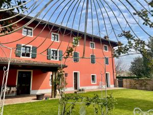 a large red building with a large roof at Fiori Di Maggio in Muscletto