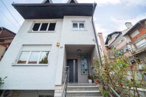 a white house with a black roof at Urban Cozy Apartments Zagreb in Zagreb