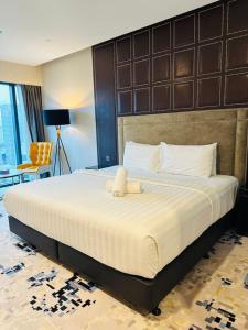 a bedroom with a large bed with a teddy bear on it at Platinum Suites KLCC SKY WORLD in Kuala Lumpur