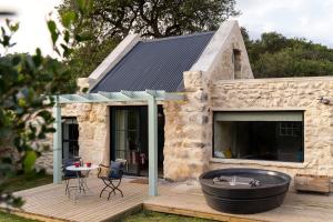 une maison en pierre avec un jacuzzi sur une terrasse dans l'établissement Coot Club, à Stanford