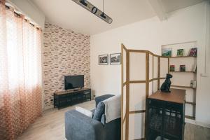 un salon avec un canapé bleu et une télévision dans l'établissement "Le cocon de Sapiac" à deux pas du stade, garage, à Montauban