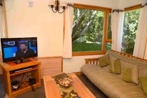 a living room with a couch and a flat screen tv at Matices Patagonicos in San Carlos de Bariloche