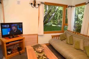 sala de estar con sofá y TV de pantalla plana en Matices Patagonicos en San Carlos de Bariloche