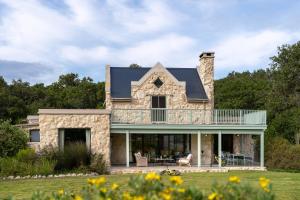 a stone house with a wrap around porch at Coot Club in Stanford