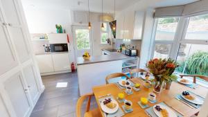 a kitchen and dining room with a table with food on it at Georgeham Windsor Cottage 3 Bedrooms in Georgeham