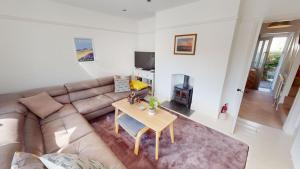 a living room with a couch and a table at Georgeham Windsor Cottage 3 Bedrooms in Georgeham