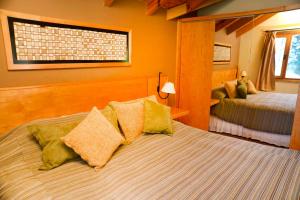 une chambre avec deux lits et une fenêtre dans l'établissement Matices Patagonicos, à San Carlos de Bariloche