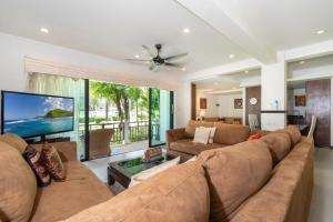 sala de estar con sofá grande y TV en Beachside Apt Short Walk to Nai Harn Beach 2-3 BR, en Nai Harn Beach