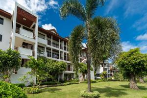 una vista exterior de un edificio con palmeras en Beachside Apt Short Walk to Nai Harn Beach 2-3 BR, en Nai Harn Beach