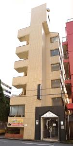 a tall building with an entry way in front of it at Hostel Inn Tokyo Ryogoku in Tokyo