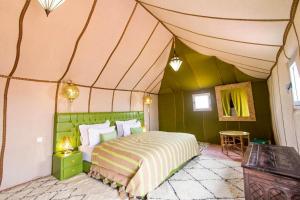a bedroom with a bed in a tent at Anir Luxury Camp - Gites et Tentes de Luxe in Merzouga