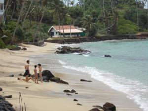a couple of people walking on a beach at Leisure Home Mirissa in Mirissa