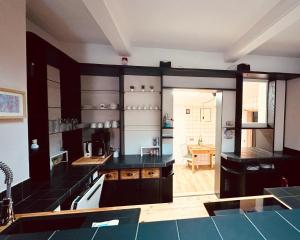 a large kitchen with black counters and a table at Schlafstall Brooksen in Bruchhausen-Vilsen